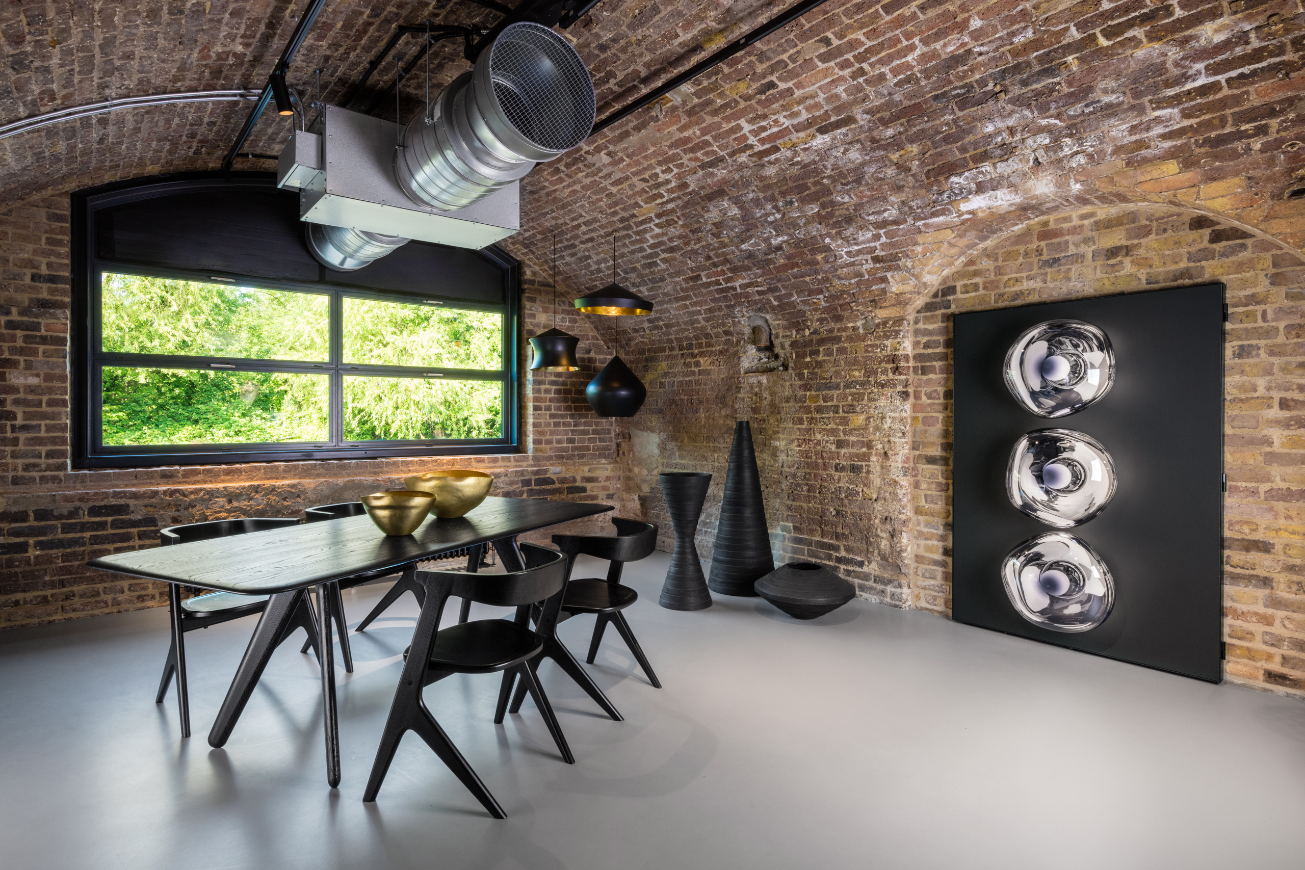 Light grey commercial resin flooring with a dining table and chairs, and an exposed brick wall