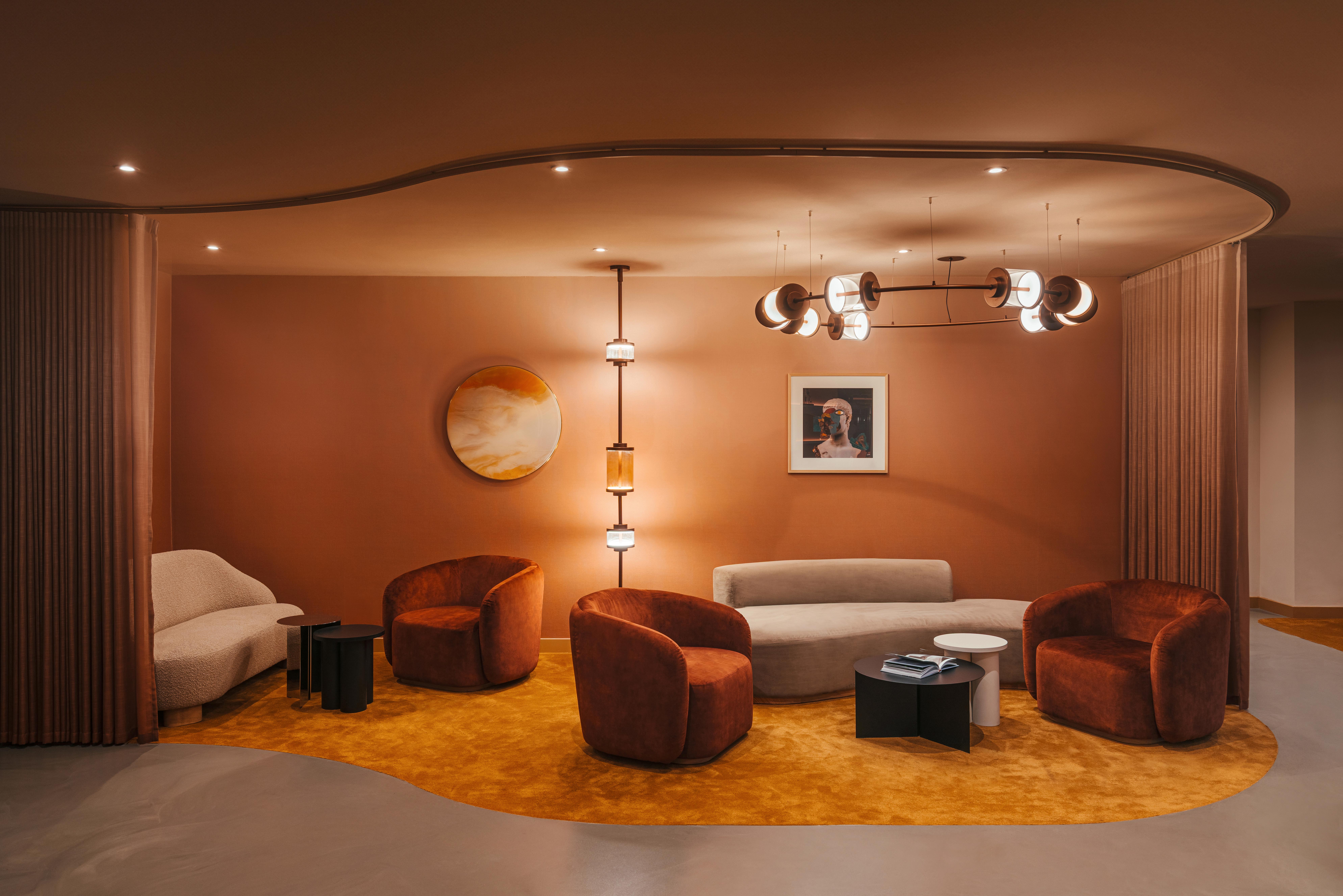 A cinematic hotel waiting area with grey resin flooring and orange carpeting