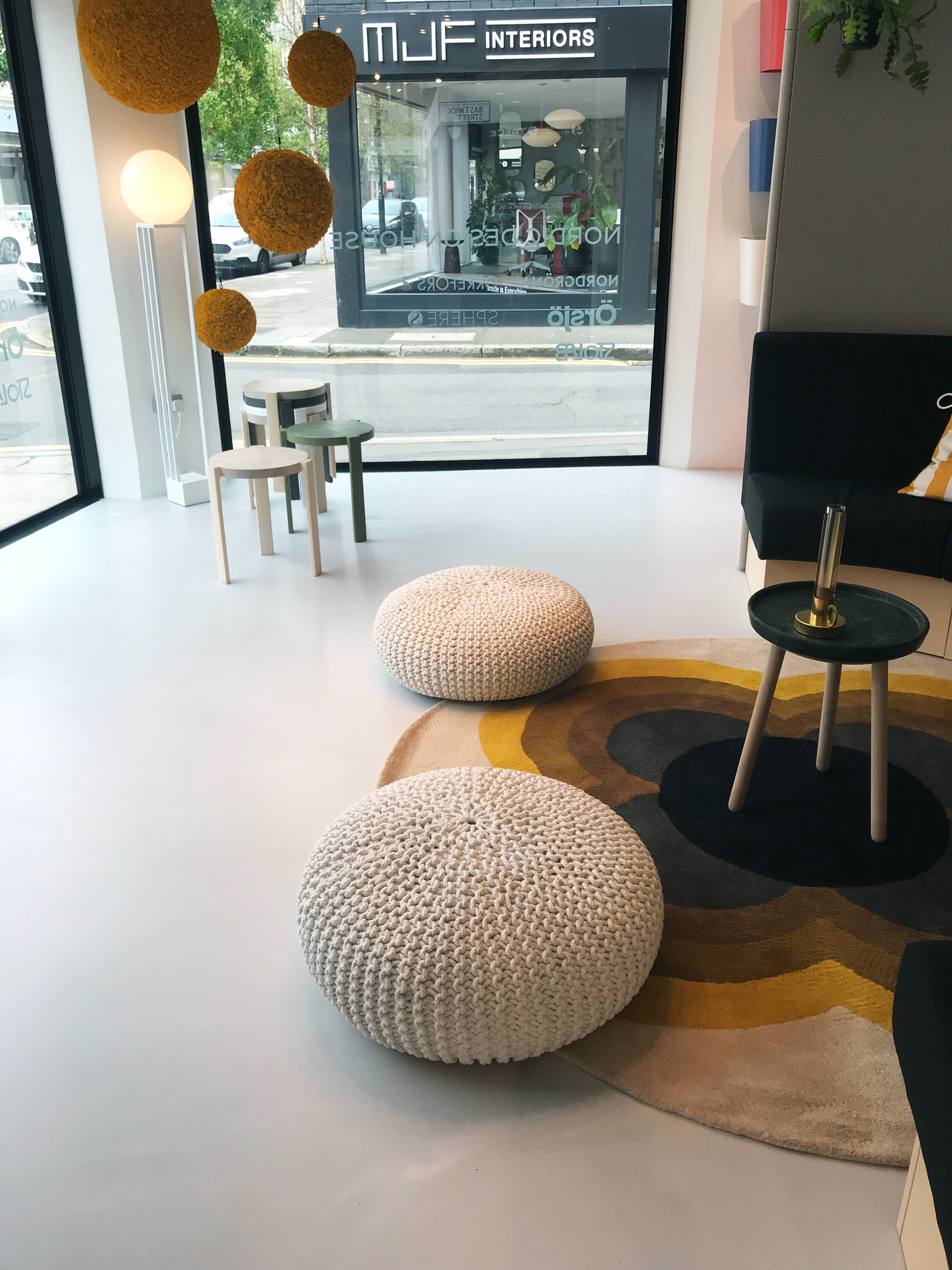Light grey resin floor in a showroom with muted-toned furniture