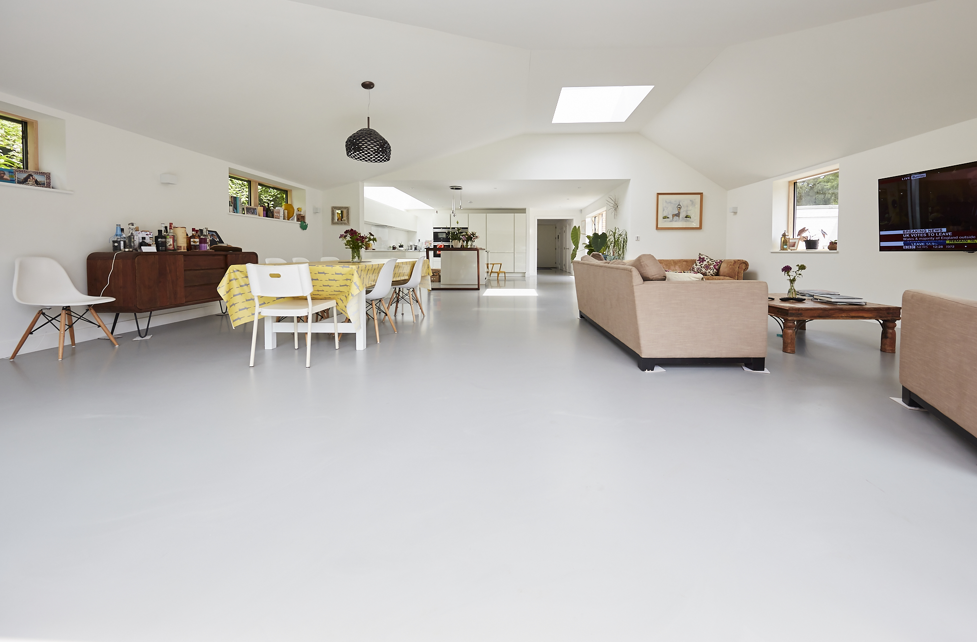 White residential resin flooring in an open plan living and dining area