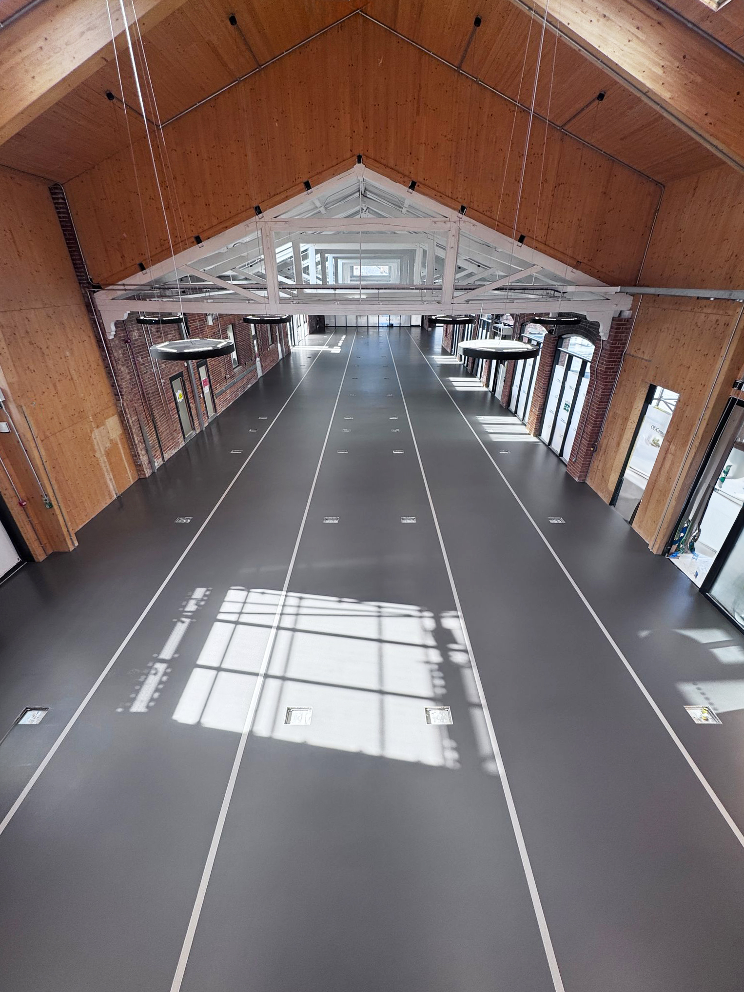 Dark grey sustainable commercial resin floor in a large open space