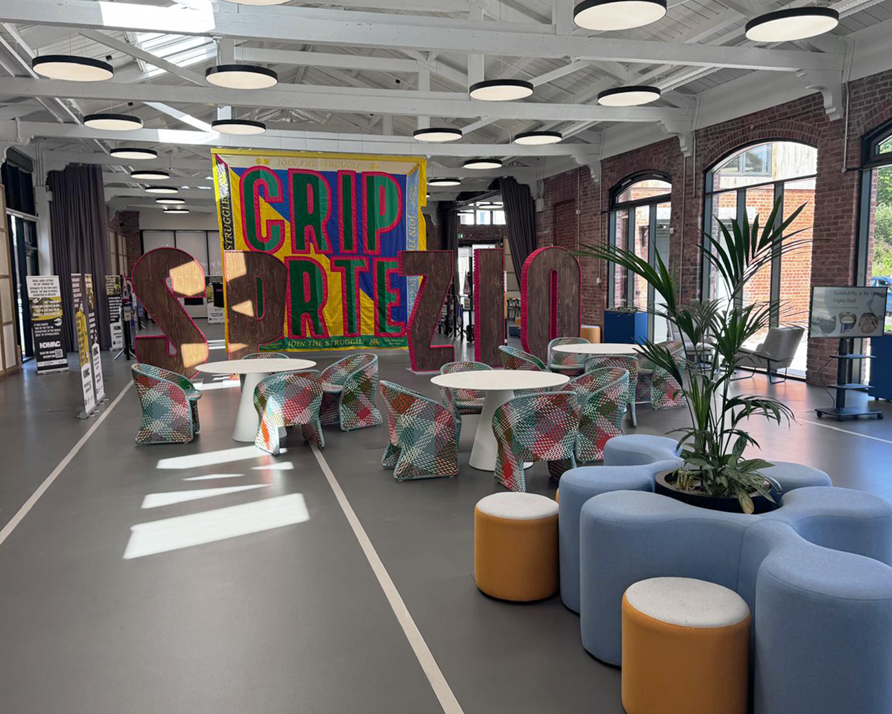 Commercial dark grey sustainable resin floor with railway tracks in a light grey. Furniture with chairs, tables and plants