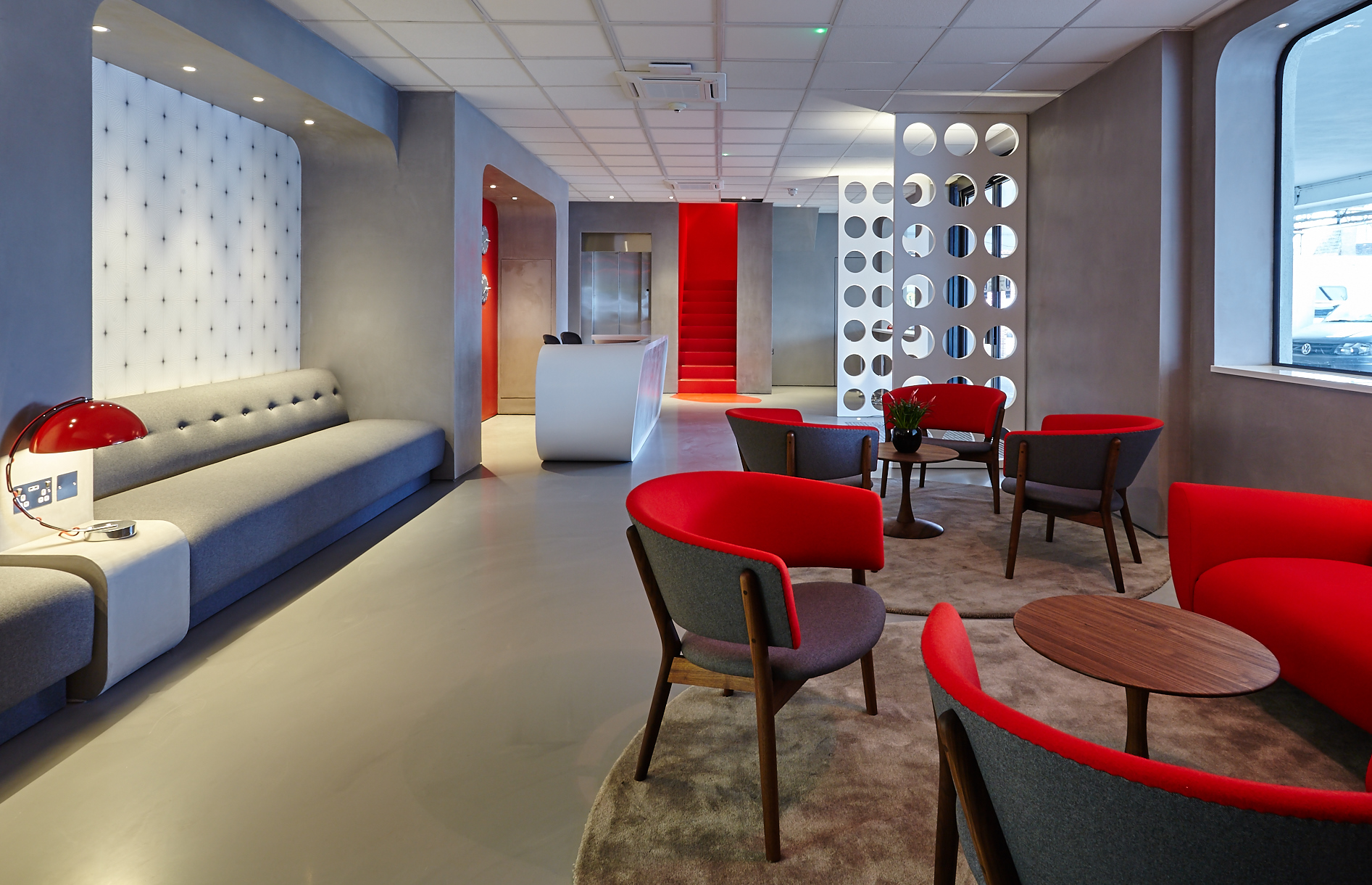 Grey commercial resin floor in an office with red furniture