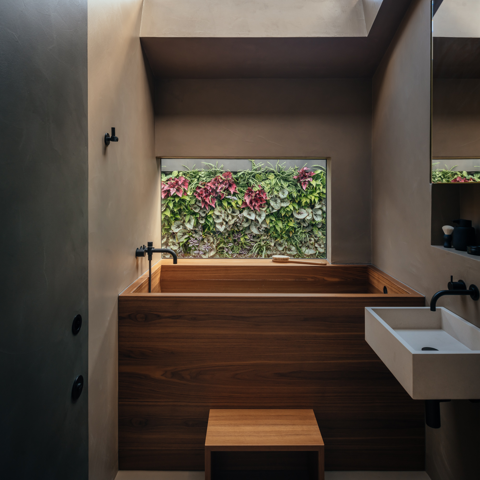 Resin walls in a bathroom with a plant wall seen through a window