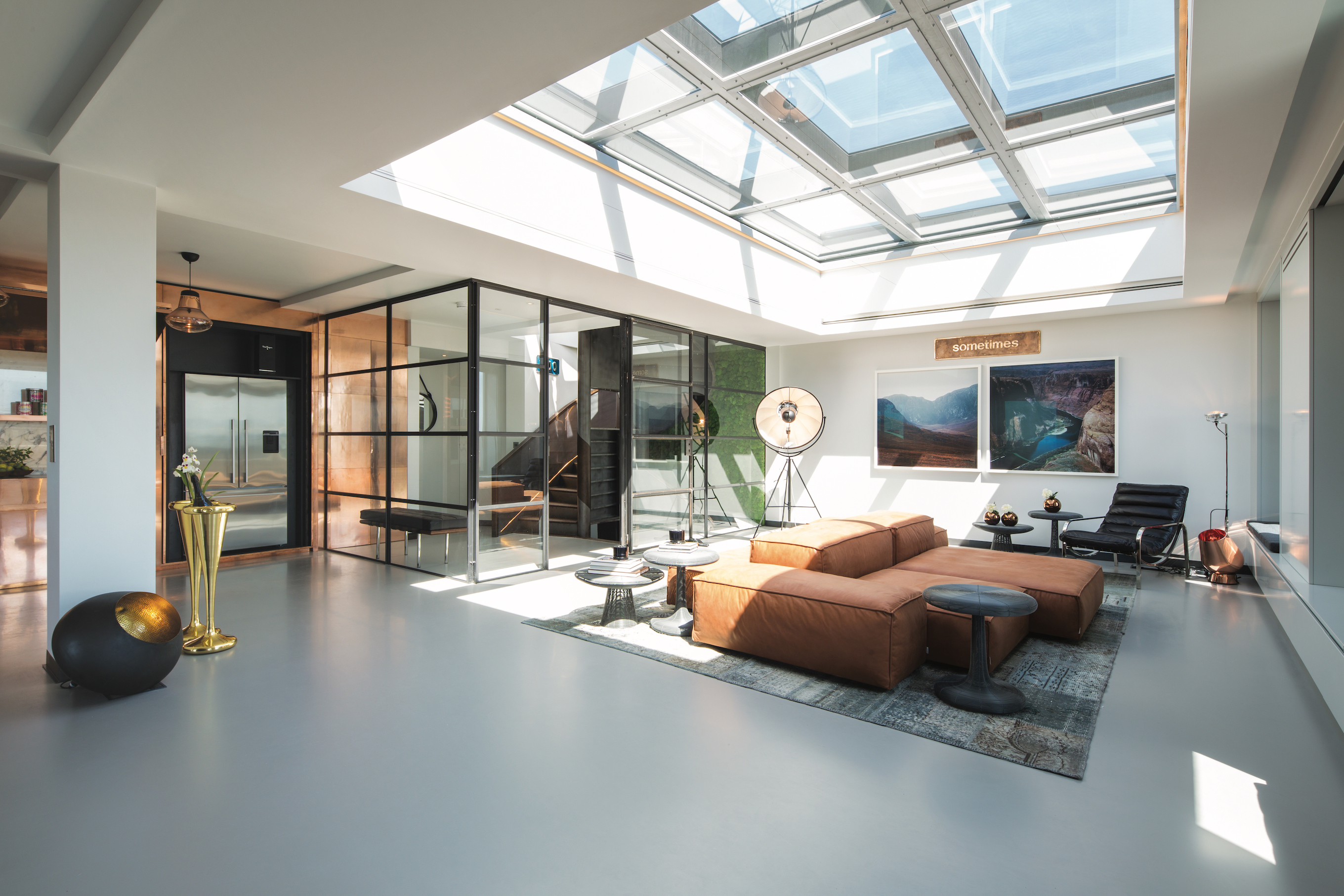 Dark grey resin living room floor with skylight and warm toned furniture
