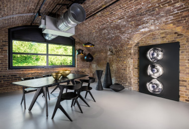 Light grey commercial resin flooring with a dining table and chairs, and an exposed brick wall