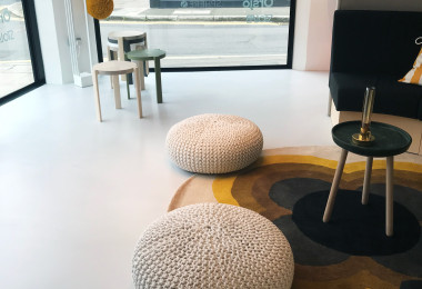 Light grey resin floor in a showroom with muted-toned furniture