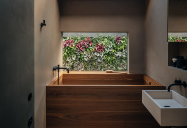 Resin walls in a bathroom with a plant wall seen through a window