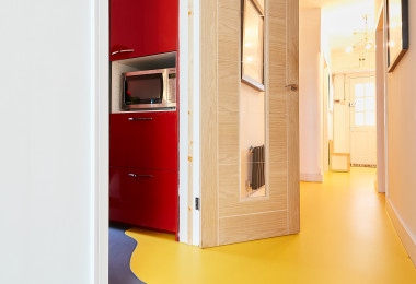 A grey and yellow resin floor in a home with a wavy split between the colours