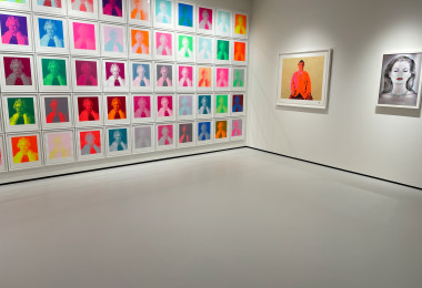 Light grey resin museum floor with brightly coloured artwork on the walls