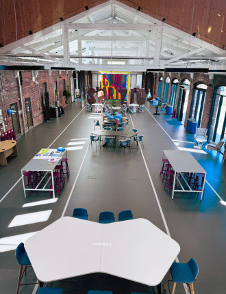 Commercial dark grey resin floor with railway tracks in a light grey, with furniture for a cafe