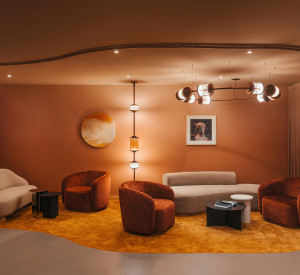 A cinematic hotel waiting area with grey resin flooring and orange carpeting