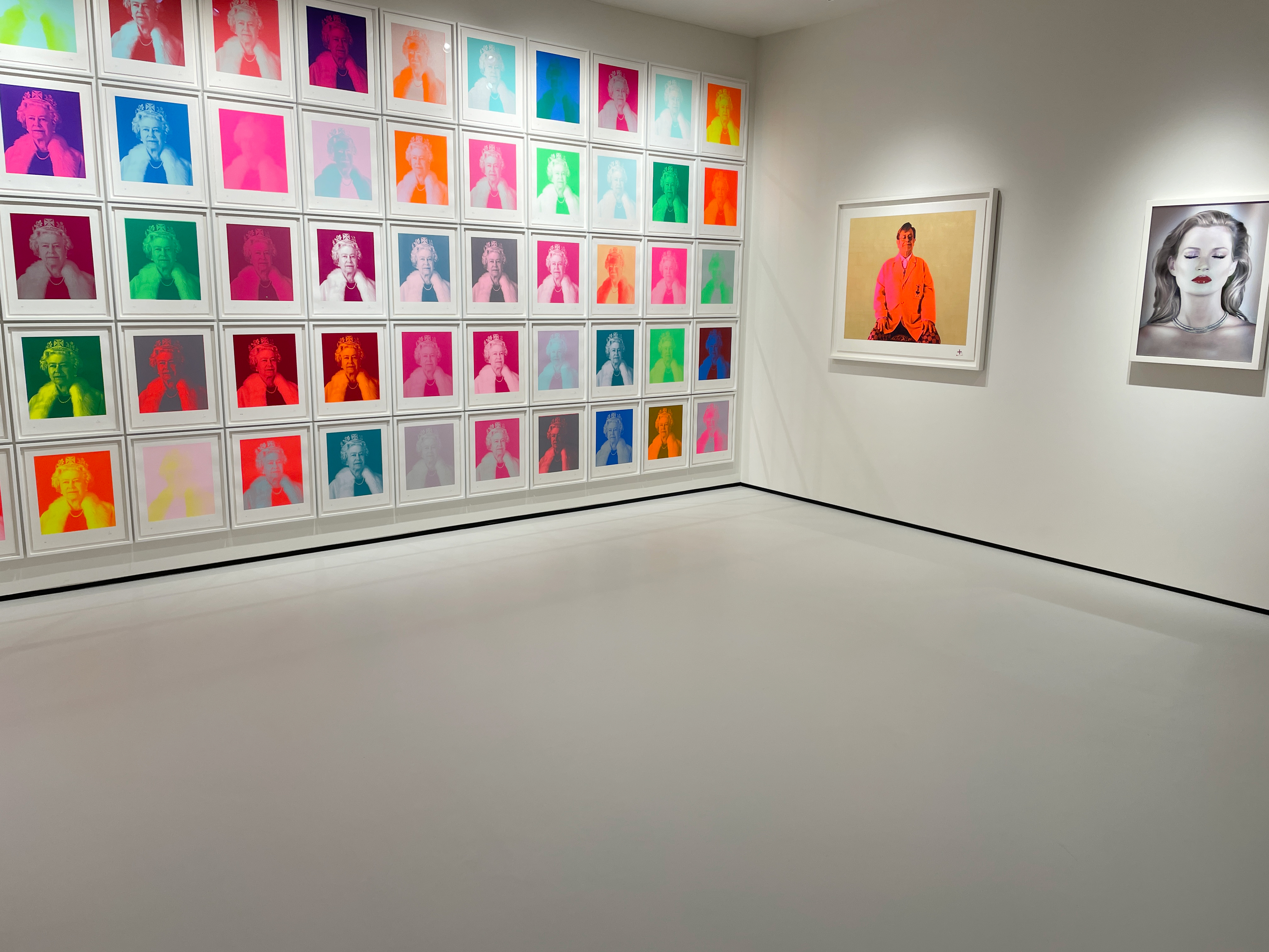 Light grey resin museum floor with brightly coloured artwork on the walls