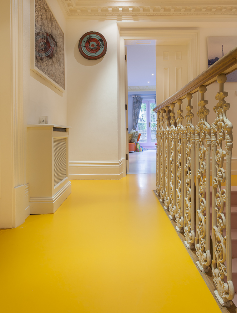 A yellow resin floor in a home hallway