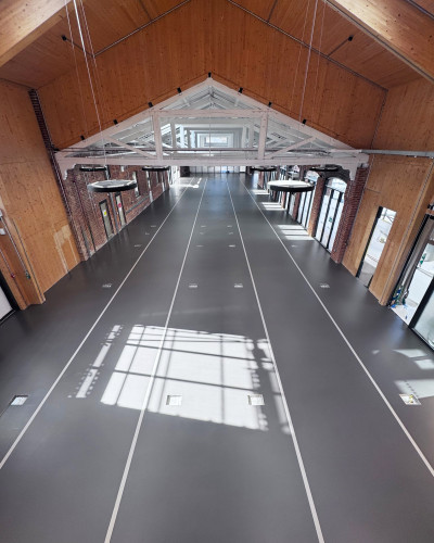 Dark grey sustainable commercial resin floor in a large open space