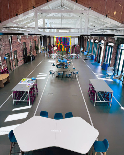 Commercial dark grey resin floor with railway tracks in a light grey, with furniture for a cafe